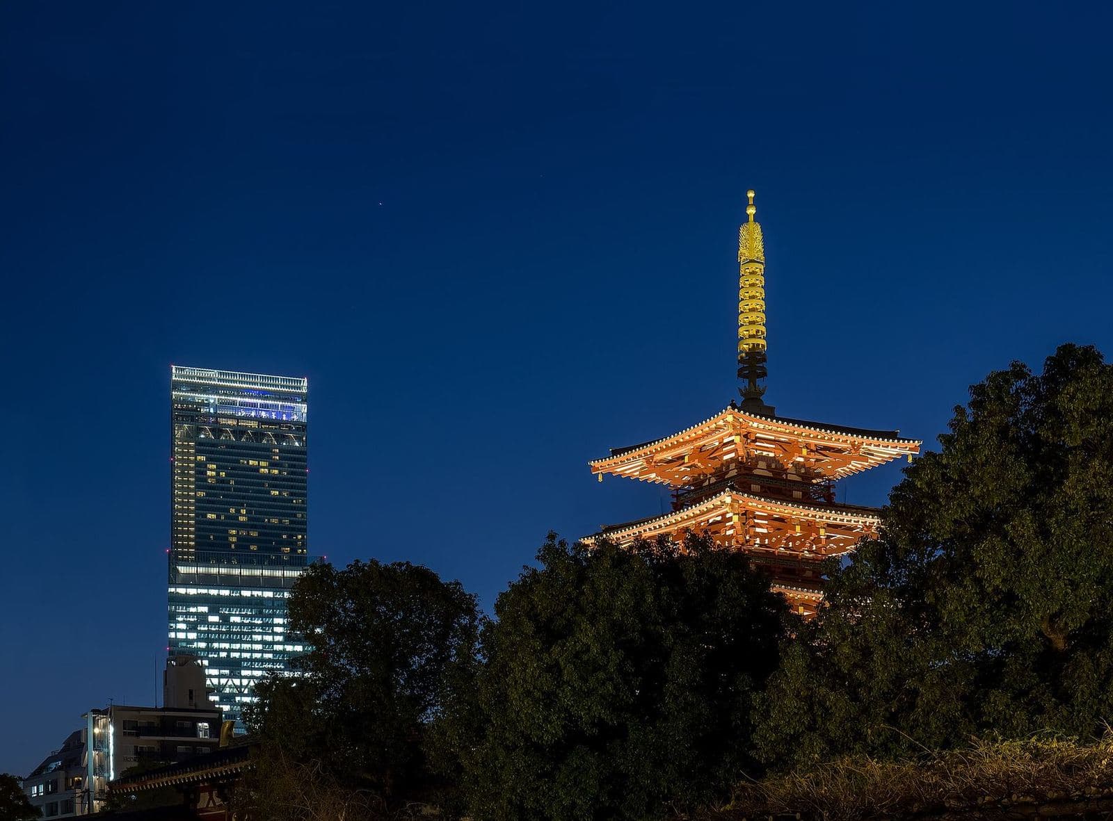 Pagoda de cinco pisos de Shitennoji al anochecer, con Abeno Harukas detrás